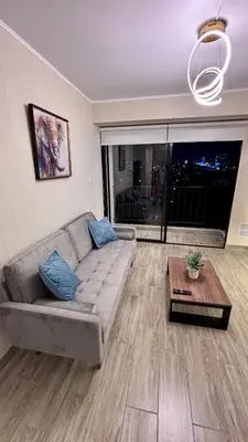 a living room with a couch and a table at 1 dormitorio moderno con balcon a 5 min de parque Kennedy-Miraflores in Lima