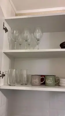 a shelf with wine glasses and cups on it at 1 dormitorio moderno con balcon a 5 min de parque Kennedy-Miraflores in Lima