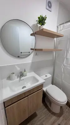 a bathroom with a sink and a mirror and a toilet at 1 dormitorio moderno con balcon a 5 min de parque Kennedy-Miraflores in Lima