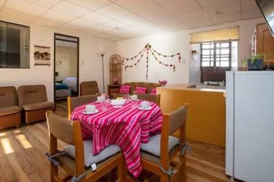 a kitchen with a table with a red and white striped table cloth at Departamento a 2 cuadras de la Plaza de Armas in Cusco