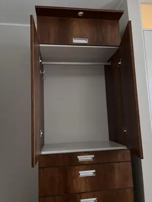 a closet with wooden drawers and a shelf at Misi House Hostal in Lima