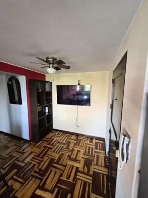 a living room with a ceiling fan and a floor at Apartamento Acogedor, tranquilo y privado in Lima