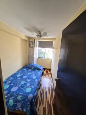 a bedroom with a blue bed and a window at Apartamento Acogedor, tranquilo y privado in Lima