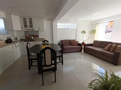 a kitchen and living room with a table and a couch at Apart El Alba III en Centro Historico de Cusco in Cusco