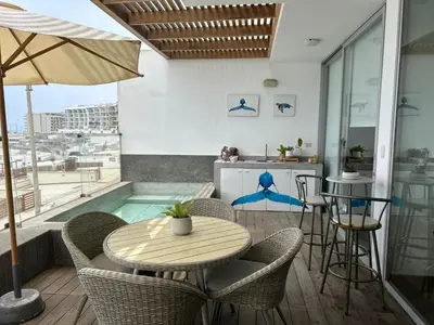 a patio with a table and chairs and a kitchen at Punta Hermosa in Punta Hermosa
