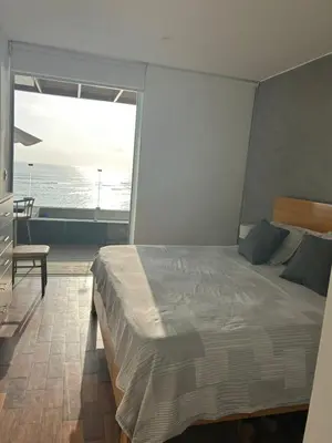 a bedroom with a bed and a view of the ocean at Punta Hermosa in Punta Hermosa