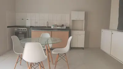 a kitchen with a glass table and white chairs at DEPARTAMENTO AMOBLADO POR TEMPORADA DE PLAYA En PUNTA HERMOSA in Punta Hermosa