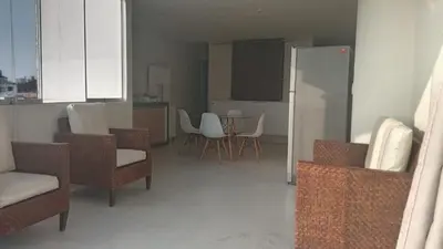 a living room with chairs and a kitchen with a refrigerator at DEPARTAMENTO AMOBLADO POR TEMPORADA DE PLAYA En PUNTA HERMOSA in Punta Hermosa
