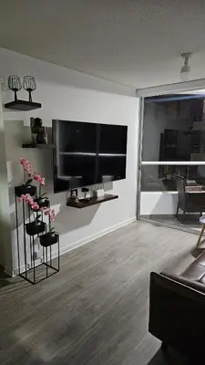 a living room with a large flat screen tv on the wall at Ocean Sunset vista al mar, piscina y balcón in Lima