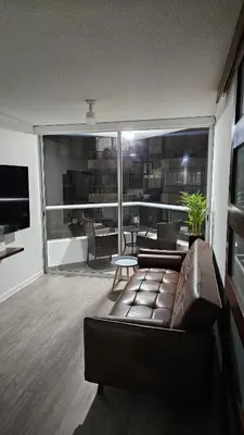a living room with a leather couch and a large window at Ocean Sunset vista al mar, piscina y balcón in Lima