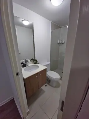 a bathroom with a sink and a toilet and a mirror at Ocean Sunset vista al mar, piscina y balcón in Lima