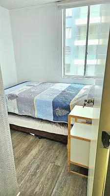 a bedroom with a bed next to a window at Ocean Sunset vista al mar, piscina y balcón in Lima