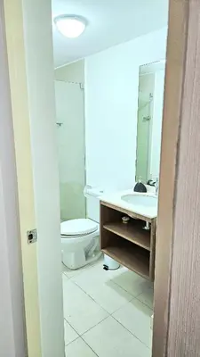 a bathroom with a toilet and a sink and a mirror at Ocean Sunset vista al mar, piscina y balcón in Lima