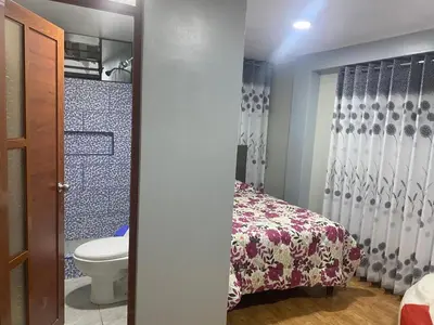a bathroom with a bed and a toilet at VICTORIA HOUSE - Huancayo - Hualhuas in Hualhuas
