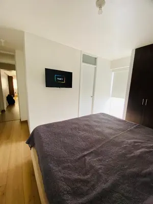 a bedroom with a bed with a clock on the wall at Moderno Smart Home San Miguel - Self check in in Lima