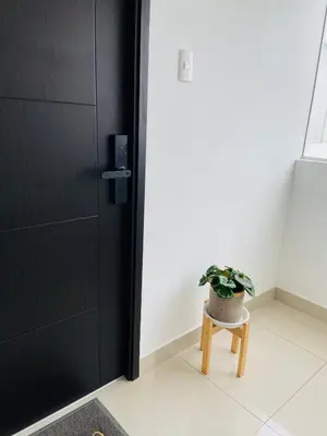 a plant sitting on a stool next to a door at Moderno Smart Home San Miguel - Self check in in Lima