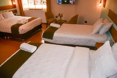 a hotel room with three beds in a room at Hotel Boutique MIRANDO AL SOL in Ollantaytambo