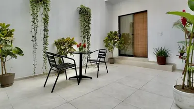 a patio with a table and chairs and plants at Luxury mini, beautiful tip in Punta Hermosa