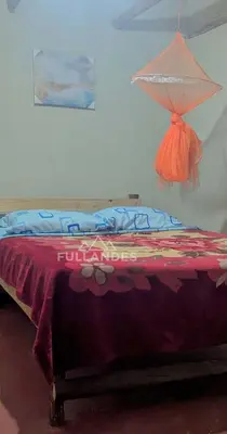 a bed in a room with a red blanket on it at Casitas Choquequirao Chikiska in Abancay