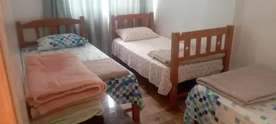 a small room with two twin beds in it at CERRO AZUL Alojamiento DUPLEX in Cerro Azul