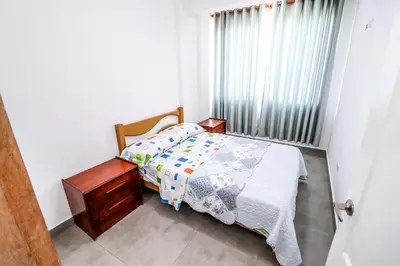 a small bedroom with a bed and a window at CERRO AZUL Alojamiento DUPLEX in Cerro Azul