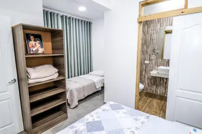 a small bedroom with two beds and a mirror at CERRO AZUL Alojamiento DUPLEX in Cerro Azul