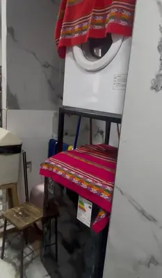 a washing machine and a table in a room at Cuarto privado en departamento compartido in Lima