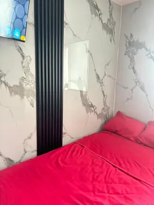 a bedroom with a red bed with a red blanket at Cuarto privado en departamento compartido in Lima