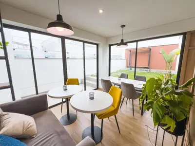 a room with two tables and chairs and windows at Cuarto privado en departamento compartido in Lima