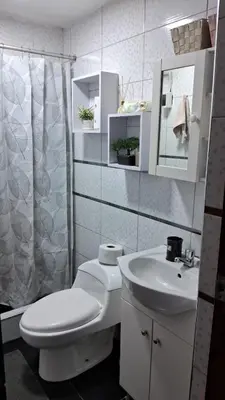 a white bathroom with a toilet and a sink at Relax Department in Lima