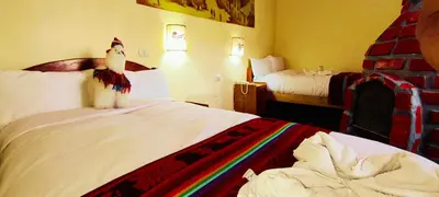 a hotel room with a bed with a stuffed penguin on it at PLAZA cusco Amankay in Cusco