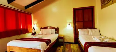 a hotel room with two beds and red curtains at PLAZA cusco Amankay in Cusco