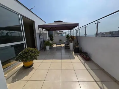 a balcony with an umbrella and plants on a building at Los Nogales LS in Lima