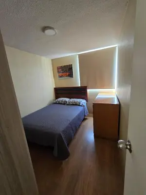 a small bedroom with a bed and a table at Los Nogales LS in Lima