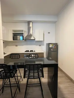 a kitchen with a table and chairs and a refrigerator at Beautiful penthouse in the heart of Miraflores in Lima