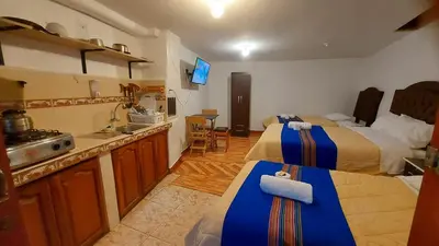a room with two beds and a kitchen with a sink at Altos Del Valle in Cusco