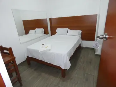 a hotel room with a bed and a mirror at Hotel Lima Norte in Carabayllo