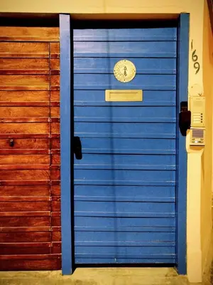 a blue garage door with a clock on it at Casa Cota in Lima