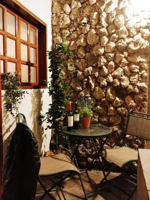 a table with two bottles of wine on it next to a stone wall at Suite C-1 Wifi 1000 Mbps, recojo gratis aeropuerto in Lima