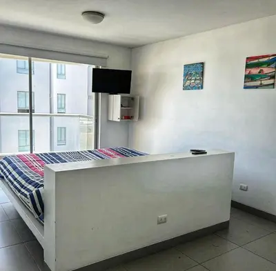 a bedroom with a bed and a large window at Paracas Exclusivo Departamento familiar in Pisco