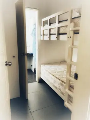 a small bedroom with a bunk bed and a ladder at Paracas Exclusivo Departamento familiar in Pisco