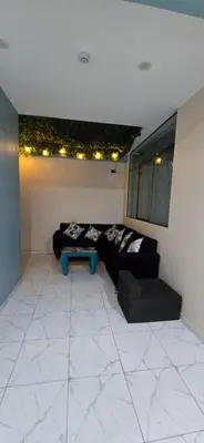 a living room with a black couch and a table at Hotel gym club33 in Huancayo