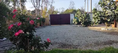 a garden with a gate and pink roses at Casa rústica in Ica