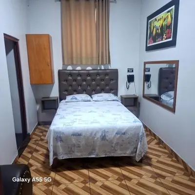 a bedroom with a large bed and a mirror at Anciejo inn ll in Lima