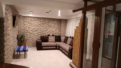 a living room with a couch and a stone wall at Hotel Wasichay - Santa teresa in Santa Teresa
