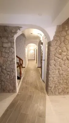 a hallway of a building with a stone wall at Hotel Wasichay - Santa teresa in Santa Teresa