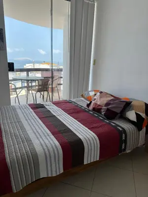 a bed in a bedroom with a view of a balcony at Departamento en Playa Pulpos - 2 habitaciones - Piscina compartida in Arica