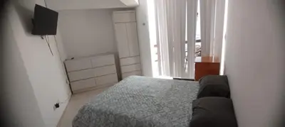 a small bedroom with a bed and a television at Departamento en Playa Pulpos - 2 habitaciones - Piscina compartida in Arica