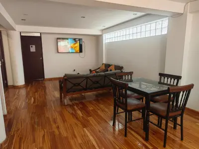 a living room with a table and chairs and a couch at Refugio Andino Cusco in Cusco