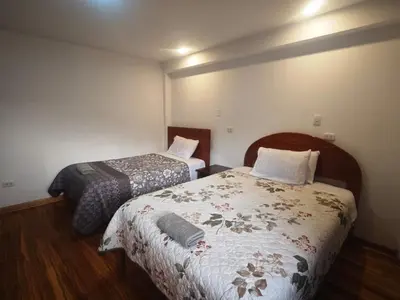 a small room with two beds in a room at Refugio Andino Cusco in Cusco